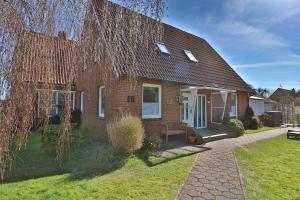 a brick house with a bench in front of it at Blüten & Meer - Haus Meer in Langeoog
