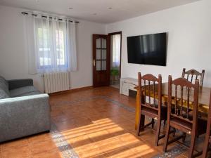 a living room with a couch and a table and a television at Mil Mariposas, Escapada rural Burgos in Barriosuso