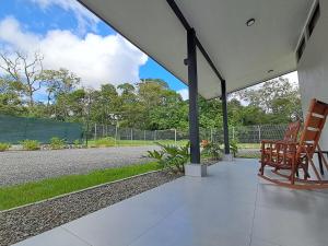 a porch with two wooden chairs sitting on it at Blue Wings Villa in Fortuna
