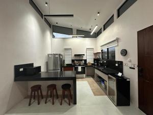 a kitchen with a black counter and stools in it at Blue Wings Villa in Fortuna