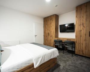 a bedroom with a bed and a desk and a tv at Boutique Hotel Una in Sarajevo
