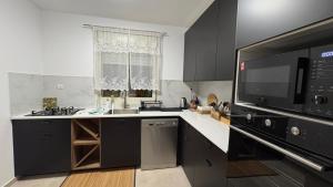 a kitchen with black cabinets and a microwave at בית נעים בין המדבר לים in Eilat