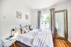 a living room with a bed and a mirror at Stylish, Private, Thoughtful, Spotless, Aircon, Parking in Hermanus