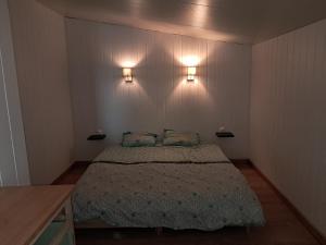 a bedroom with a bed and two lights on the wall at Studio 80m2 a la ferme tout confort in Courdemanche
