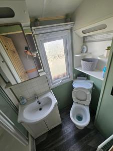 a small bathroom with a sink and a toilet at V10 static caravan in Ingoldmells +5 photos