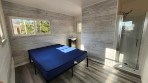 a bedroom with a blue bed and a window at Espace des Grands-Ducs - Domaine de Lacs et de forêt in Sacré-Coeur-Saguenay