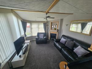 a living room with a couch and a tv at V10 static caravan in Ingoldmells