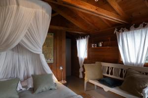 a bedroom with a bed with curtains and a couch at Orion Treehouses in Saint Paul de Vence