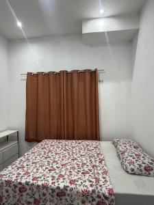 a bedroom with a bed with a red curtain at Residencial Lourenço - Vila Preá in Cruz +5 photos