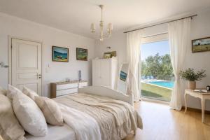 a white bedroom with a bed and a large window at Villa Olea Corfu - Private Pool & Panoramic Views in Perama +21 photos
