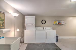 a laundry room with white appliances and a clock on the wall at Unwind and Relax in a Historic Midtown Property in Memphis +23 photos
