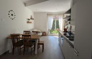 a kitchen with a table and chairs and a dining room at Appartamento La Camelia in Sondrio