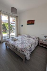 a bedroom with a bed with a floral comforter at Appartamento La Camelia in Sondrio