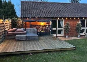 a backyard with a wooden deck with a gazebo at The Foxes Den in Assington