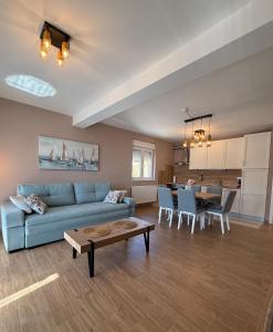 a living room with a blue couch and a table at Apartman Lovor in Primošten