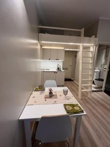 a small kitchen with a table and a loft bed at Central Kamppi Micro Loft, Quiet Courtyard in Helsinki