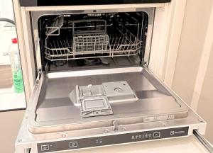 a dishwasher with its door open with a dish rack at Central Kamppi Micro Loft, Quiet Courtyard in Helsinki +12 photos
