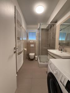 a bathroom with a toilet and a sink and a shower at Apartman Lovor in Primošten +26 photos
