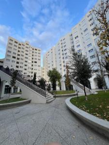 two large white buildings with stairs in a courtyard at Fabio Home in Tirana