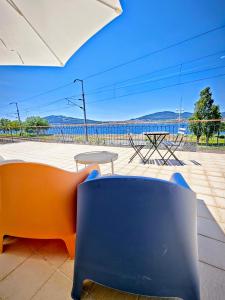 an orange and blue chair and a table and chairs at Donna Nega Guest House in Caminha