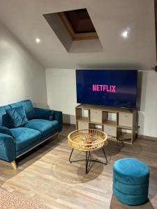 a living room with a blue couch and a tv at Le Loft in Anzin