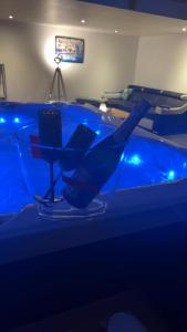 a hot tub with a glass table and a chair at Le Loft in Anzin