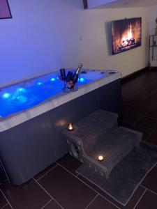 a blue swimming pool with lights in a room at Le Loft in Anzin