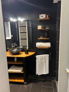 a black bathroom with a sink and a mirror at Le Loft in Anzin