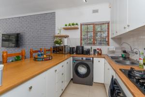 a kitchen with a washing machine on a counter at 3 Bedroom Family Home, Pool & Garden, Upper Constantia in Constantia