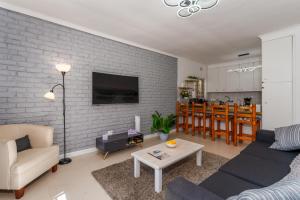 a living room with a couch and a table at 3 Bedroom Family Home, Pool & Garden, Upper Constantia in Constantia
