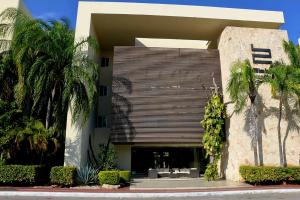 ein Gebäude mit Palmen davor in der Unterkunft Oasis del Sol in Playa del Carmen