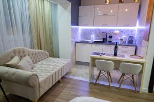 a living room with a couch and a table and a kitchen at Foča Apartman STORY in Foča