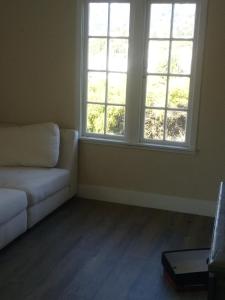 a living room with a couch and two windows at Chill Rooms in Oakland
