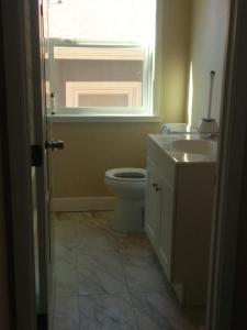 a bathroom with a toilet and a sink and a window at Chill Rooms in Oakland