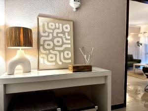 a table with a lamp and a picture on it at Sea House Apartment - Private Condo with 4 Pools, Jacuzzi & Tennis Court in Albufeira