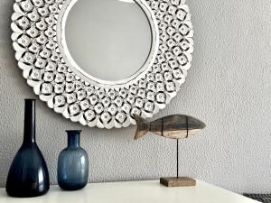 a mirror on a wall with vases on a table at Sea House Apartment - Private Condo with 4 Pools, Jacuzzi & Tennis Court in Albufeira +21 photos