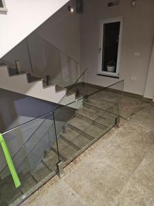 a staircase with glass railing in a building at Dino Saraj in Skopje +3 photos