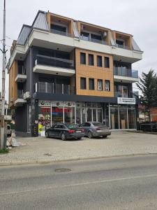 two cars parked in a parking lot in front of a building at Dino Saraj in Skopje
