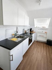 a white kitchen with white cabinets and a sink at Ulm City Appartement in Ulm