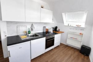 a white kitchen with white cabinets and a sink at Ulm City Appartement in Ulm +8 photos