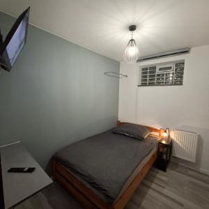 a small bedroom with a bed and a television at FORT BLIZNE NOCLEGI - superior, standard & basic rooms in Blizne Łaszczyńskiego