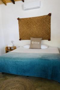 a bedroom with a bed with a blue bedspread at Casa Laud playa ventura Boutique hotel in Playa Ventura