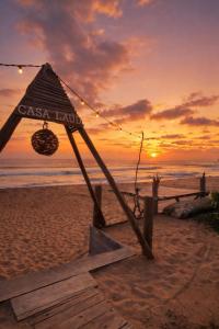 a sign on the beach with the sunset in the background at Casa Laud playa ventura Boutique hotel in Playa Ventura