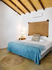 a bedroom with a large bed with a blue blanket at Casa Laud playa ventura Boutique hotel in Playa Ventura