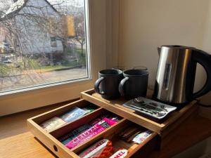 a wooden shelf with two mugs and a coffee maker at The Ullapool Rooms in Ullapool