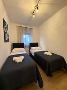 two beds in a room with two beds sidx sidx sidx at Apartman Lovor in Primošten