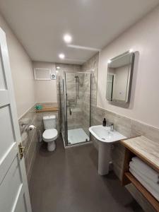 a bathroom with a shower and a toilet and a sink at The Ullapool Rooms in Ullapool +12 photos