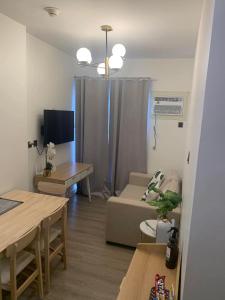 a living room with a couch and a table at Cozy 1BR with Balcony, Sea View and Pool - Fast WiFi - Snug Sanctuary in Talisay