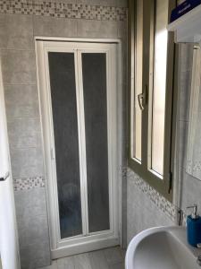 a bathroom with a shower door and a sink at Indy Sea Home in Lido degli Estensi +20 photos