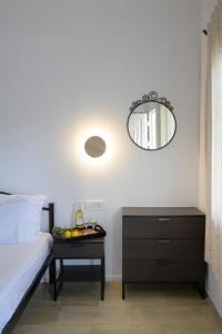 a bedroom with a bed and a table with a mirror at Milto's Studios in Parga